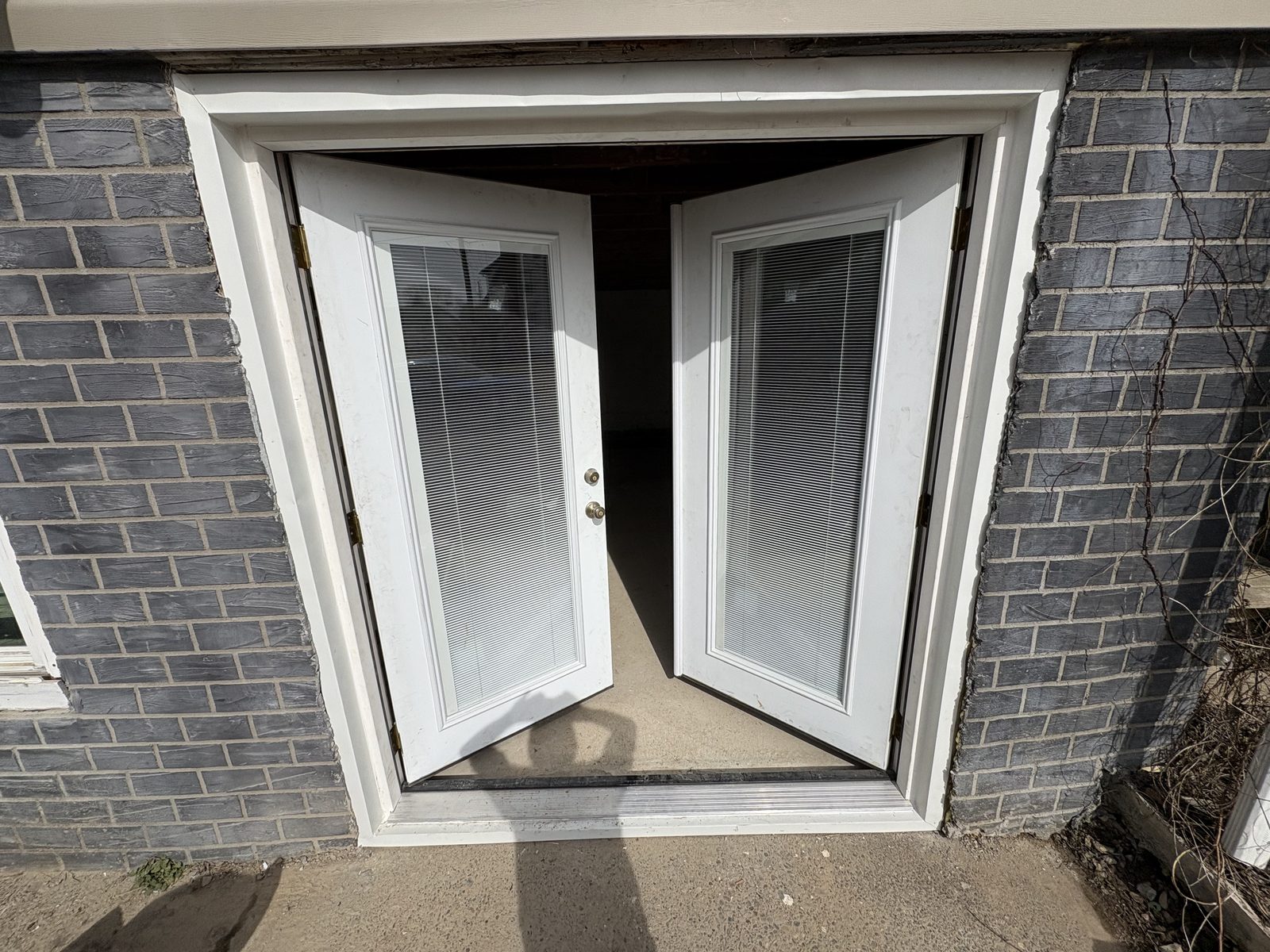 New French walkout doors set into brick foundation
